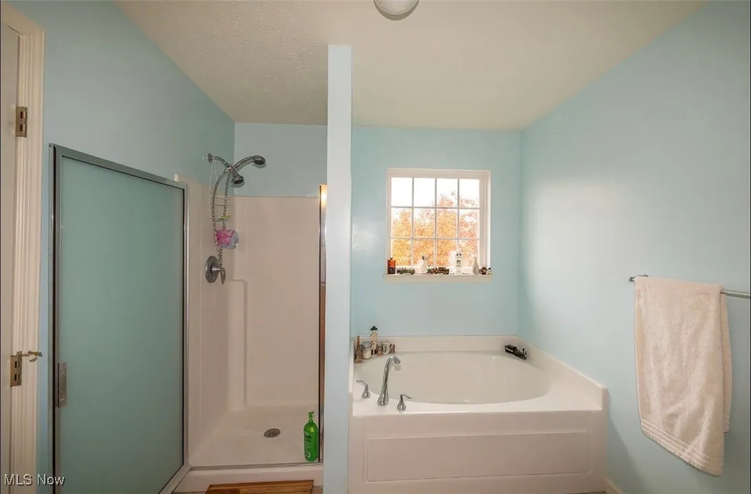 Full bathroom with a garden tub and a shower stall