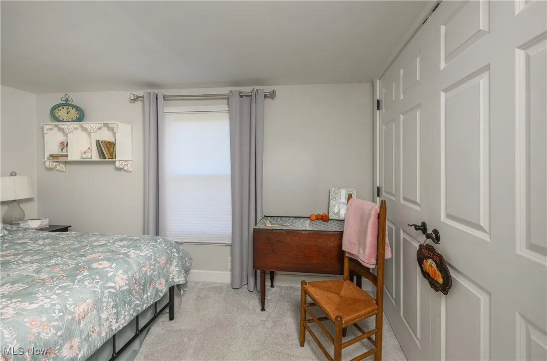 Bedroom featuring light colored carpet and baseboards