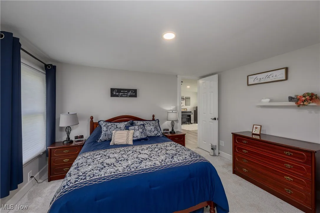 Bedroom with light colored carpet and baseboards