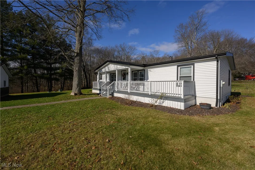 View of front facade with a front lawn and covered porch