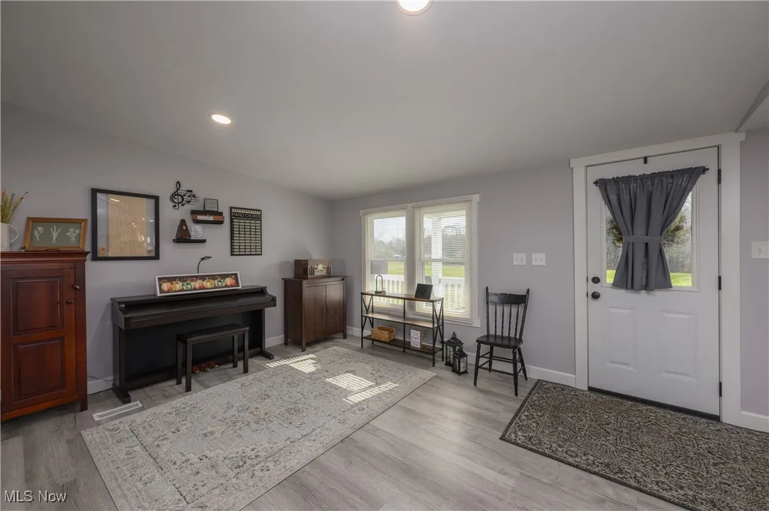 Foyer with light wood-type flooring and recessed lighting