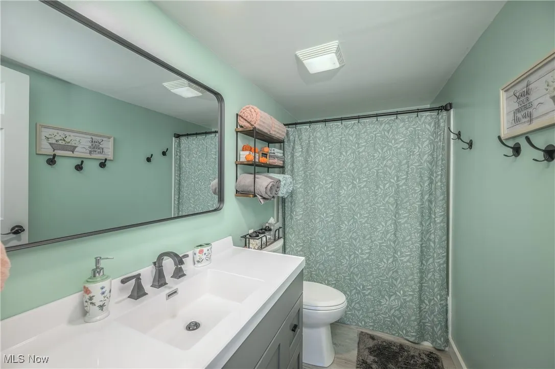 Bathroom featuring a shower with curtain and vanity