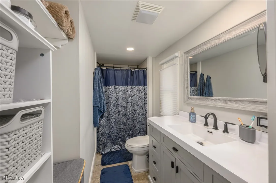 Full bath with vanity, a shower with curtain, and recessed lighting