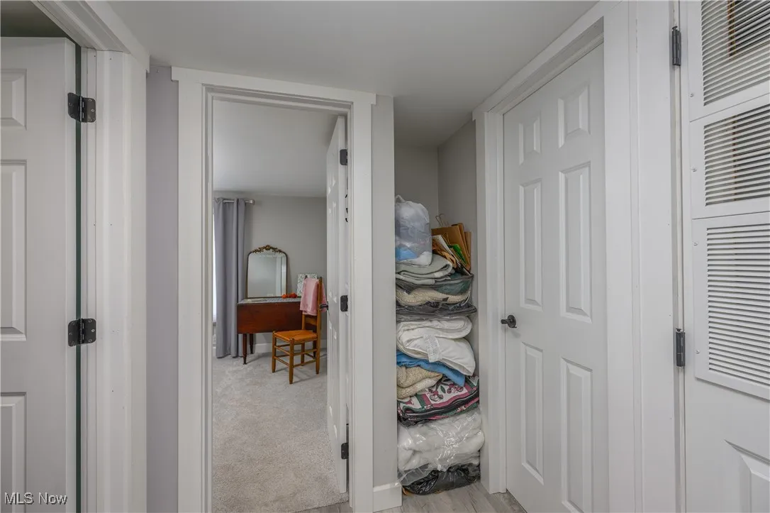 Corridor with light colored carpet and a heating unit