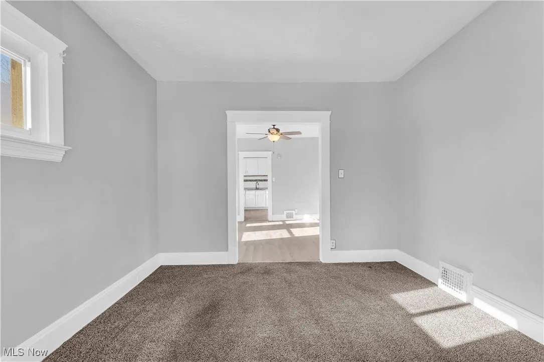 Carpeted spare room featuring baseboards