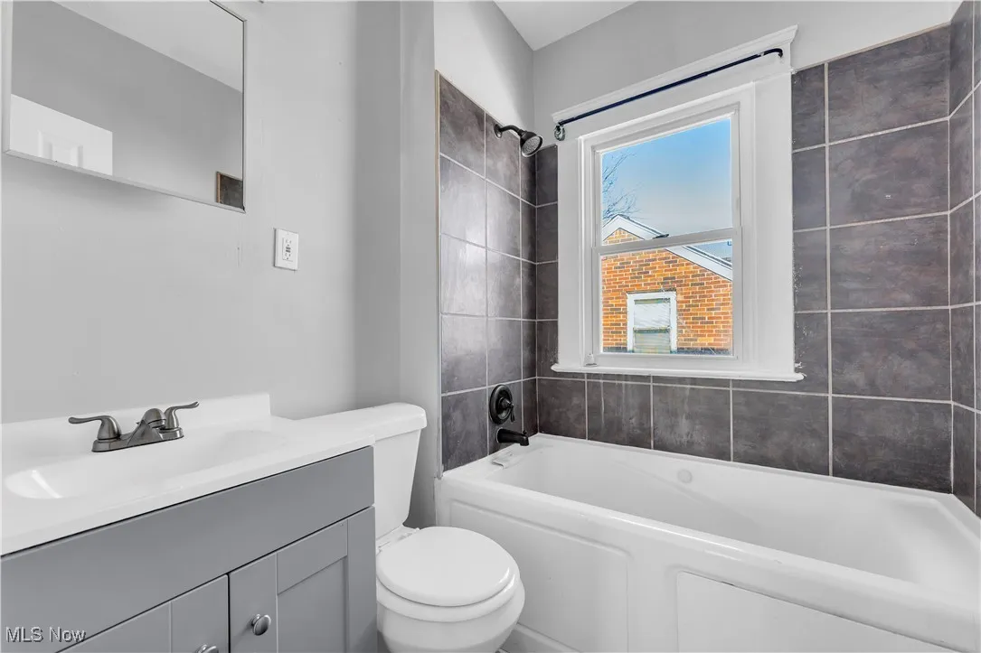 Bathroom featuring vanity and washtub / shower combination