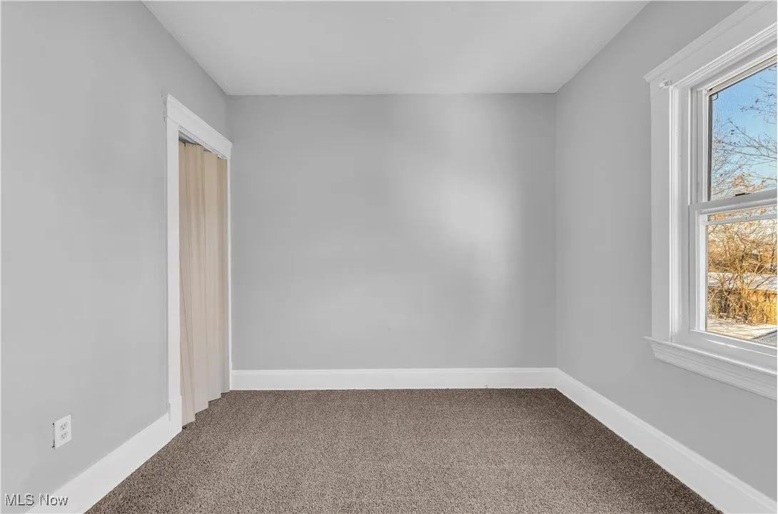 Empty room with carpet flooring and baseboards