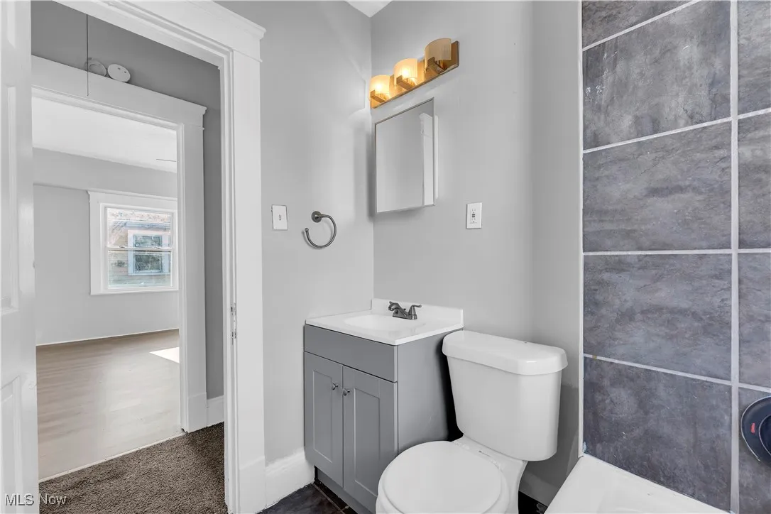 Bathroom with vanity and dark colored carpet