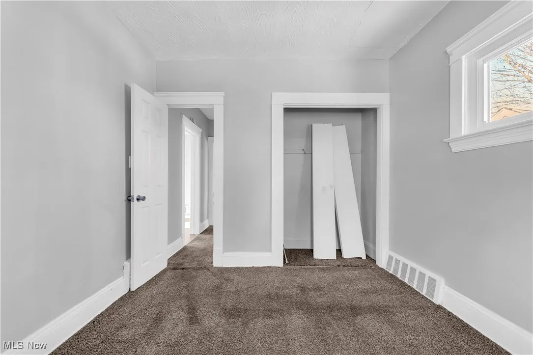 Unfurnished bedroom with carpet and a closet