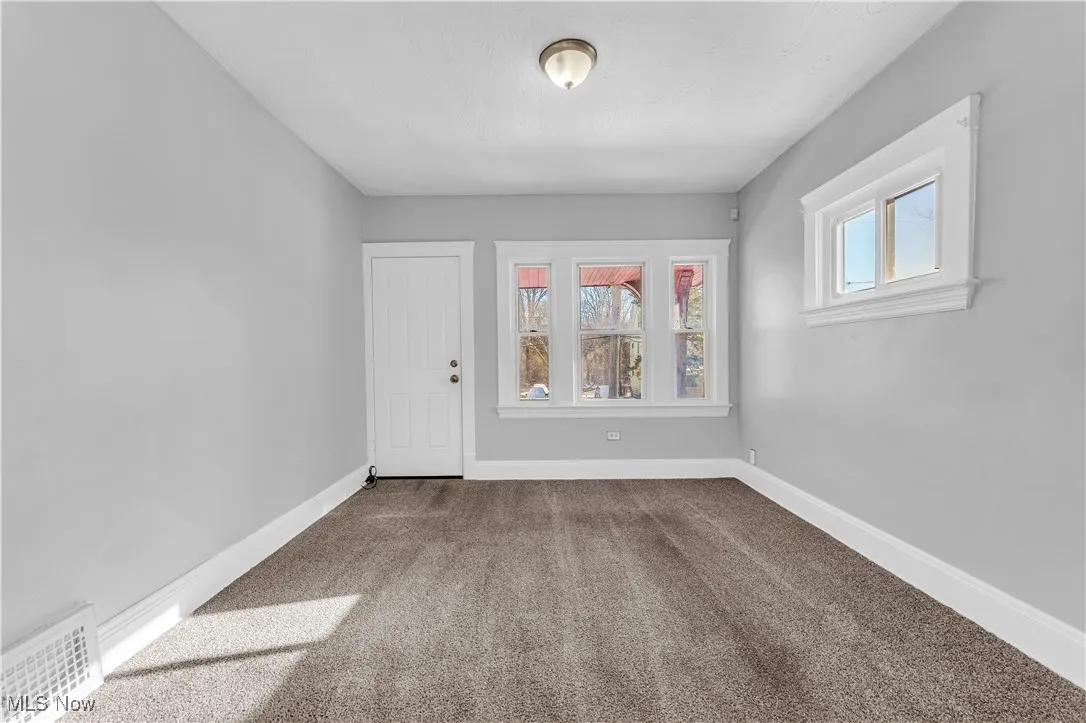 Carpeted empty room featuring healthy amount of natural light