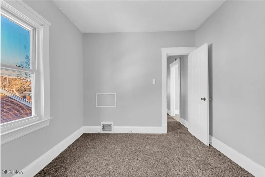 Empty room featuring carpet and baseboards