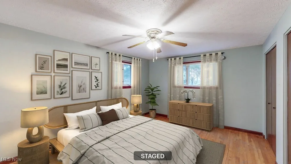 Virtually staged Bedroom featuring wood finished floors, a closet, a textured ceiling, and a ceiling fan