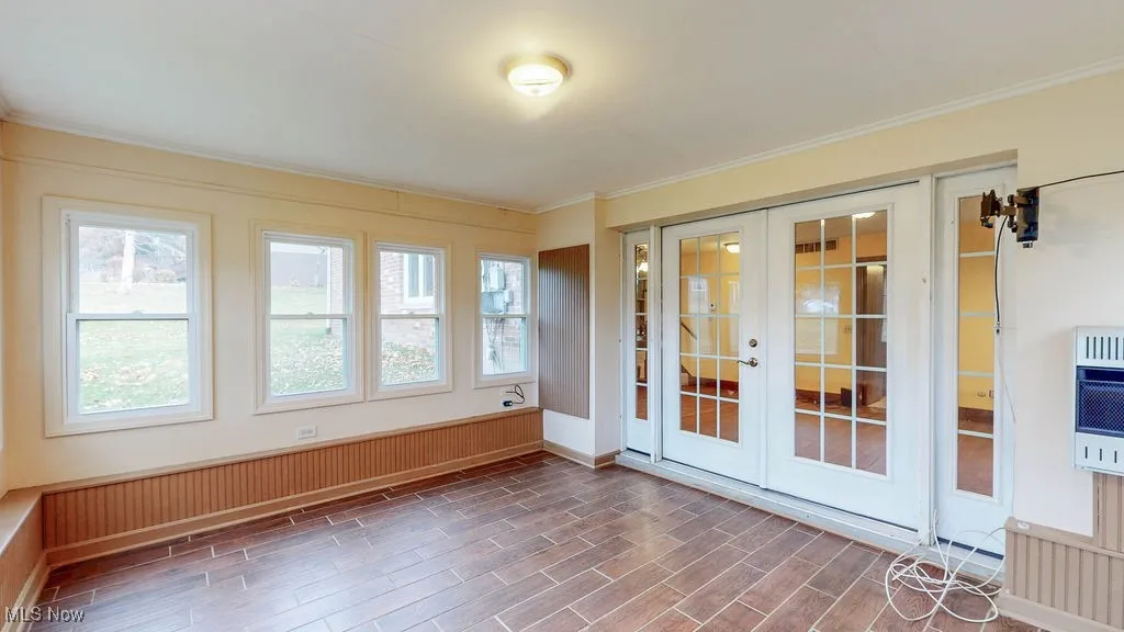 Unfurnished sunroom with french doors and heating unit