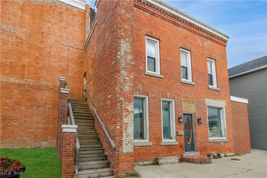 View of front of home with brick siding and stairway