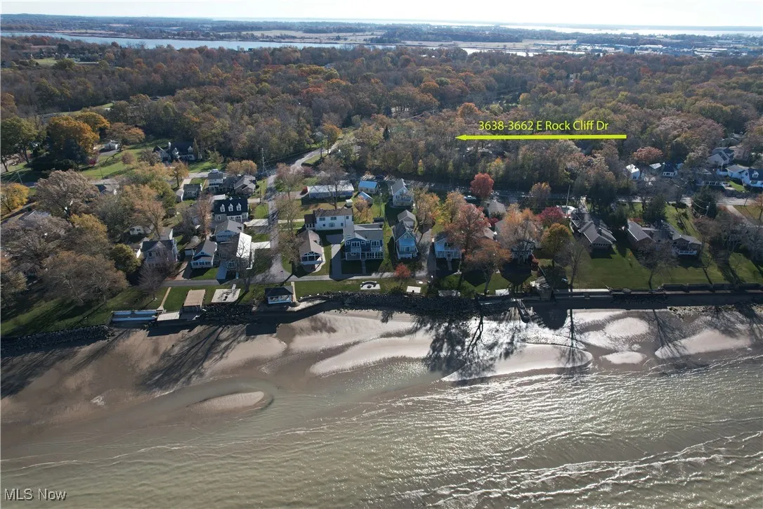 Aerial view of property and surrounding area featuring a large body of water and nearby suburban area