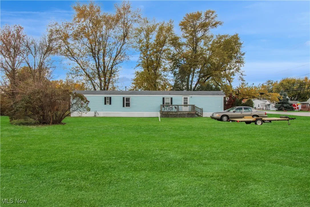 View of front of home featuring a front yard and a wooden deck