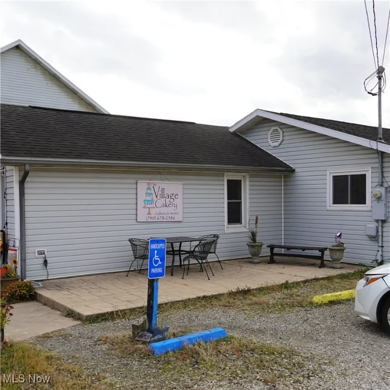Back of property featuring a patio area and roof with shingles