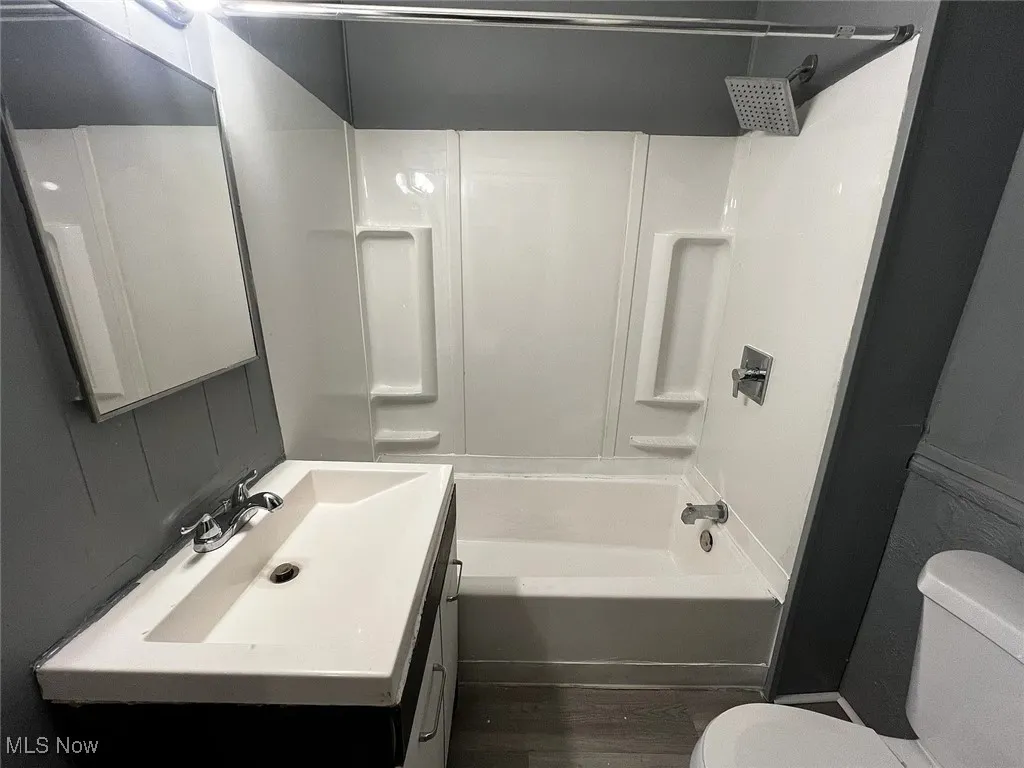 Full bathroom with  finished floors, tub / shower combination, and vanity