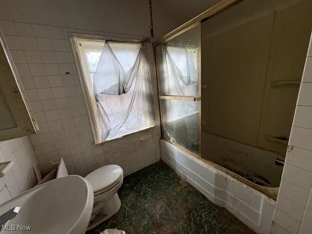 Bathroom with tile walls and shower / tub combination