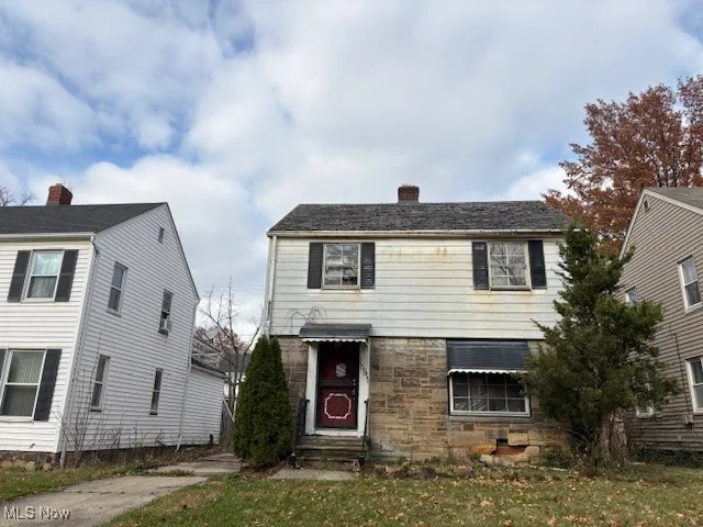 View of front facade with stone siding, a chimney, and a front lawn