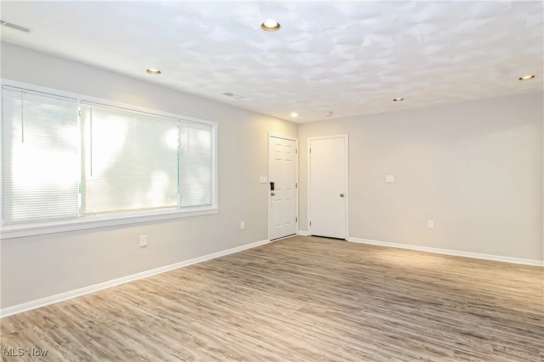 Empty room featuring light wood finished floors and recessed lighting