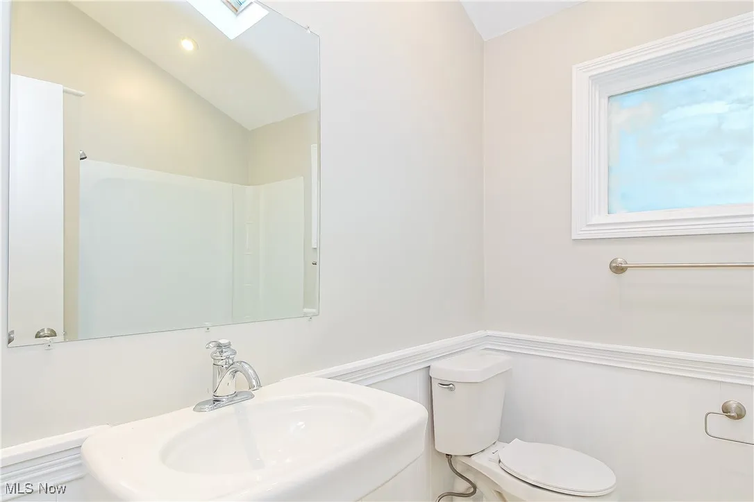 Bathroom featuring a skylight and vaulted ceiling