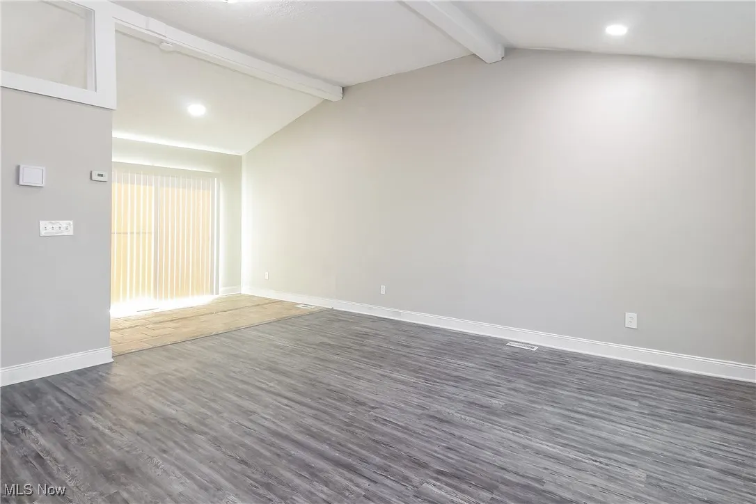 Spare room with dark wood-type flooring and recessed lighting