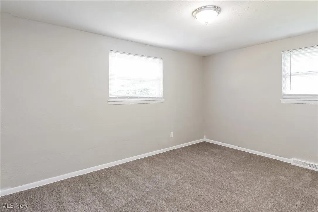 Carpeted empty room featuring baseboards
