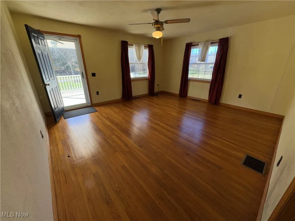Unfurnished room with hardwood / wood-style flooring and ceiling fan