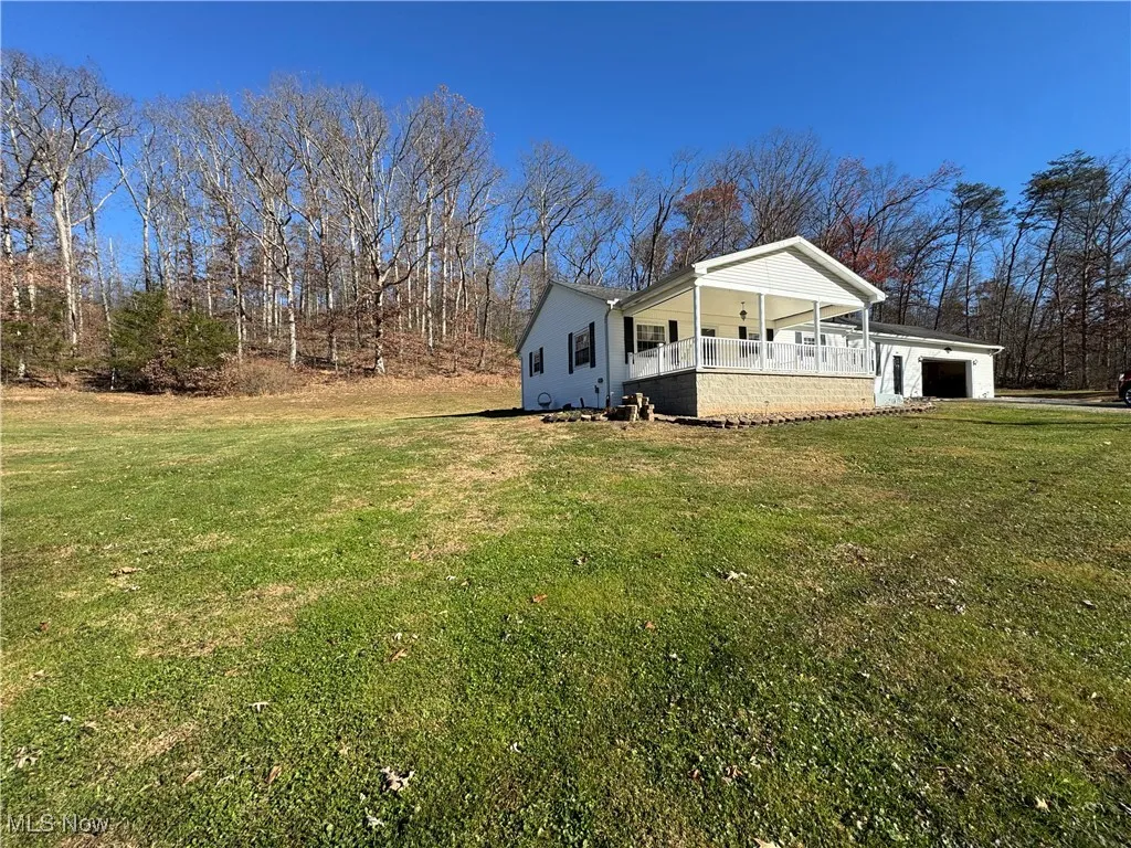 View of side of home featuring a yard and a garage