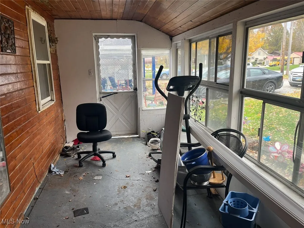 Patio featuring wooden ceiling, lofted ceiling, concrete floors, and wood walls