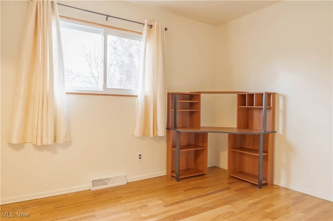 Unfurnished bedroom with baseboards and light wood-style flooring