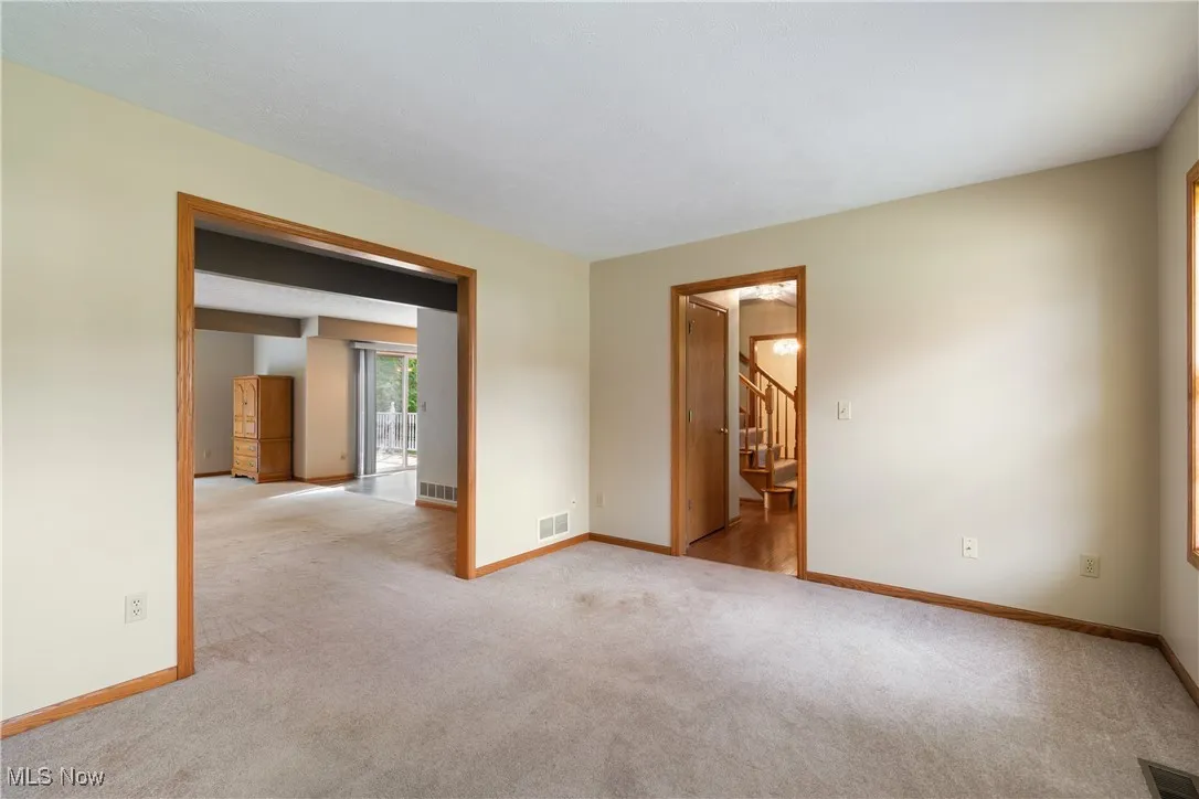 Unfurnished room with carpet and stairs