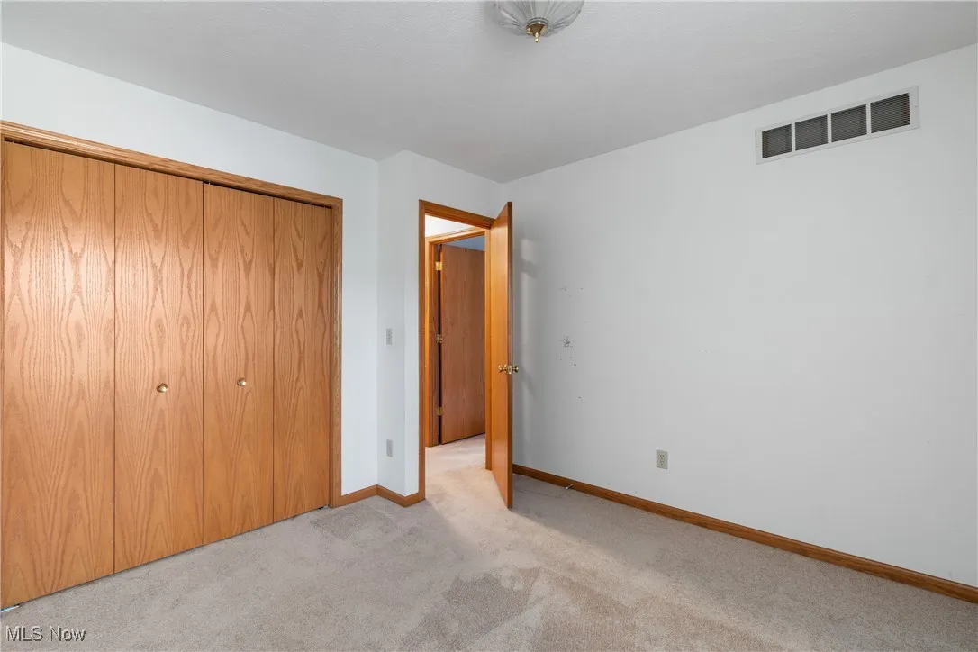 Unfurnished bedroom featuring a closet and light carpet