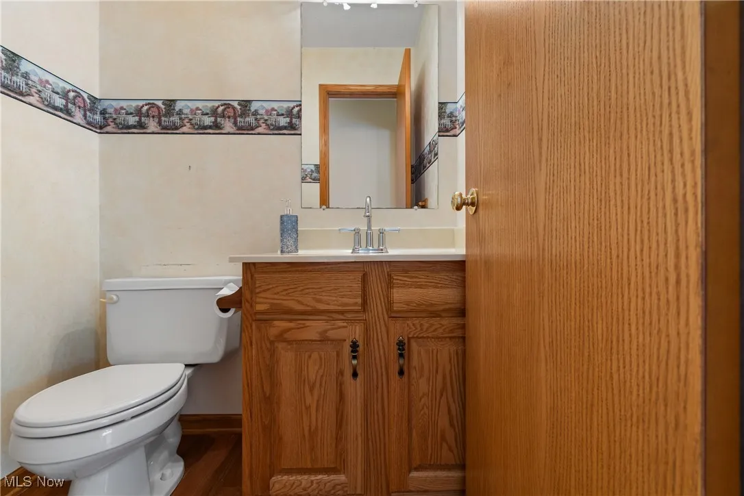 Half bath featuring vanity and wood finished floors