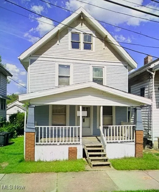 American foursquare style home with covered porch and a front yard