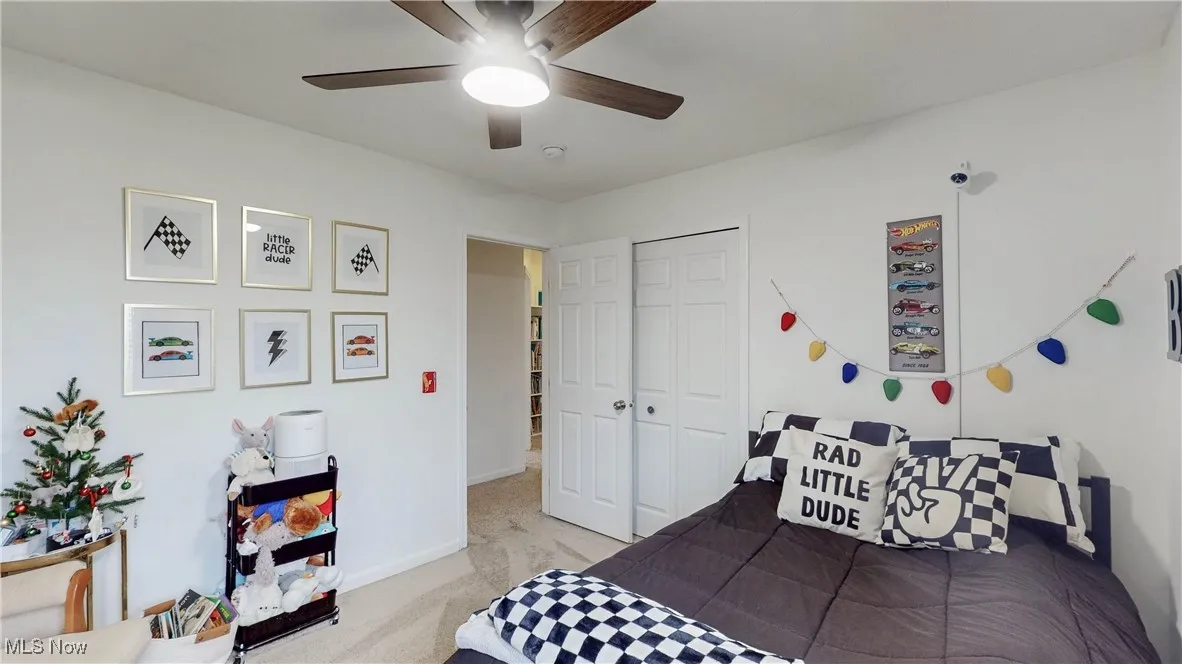 Bedroom with carpet, ceiling fan, and a closet