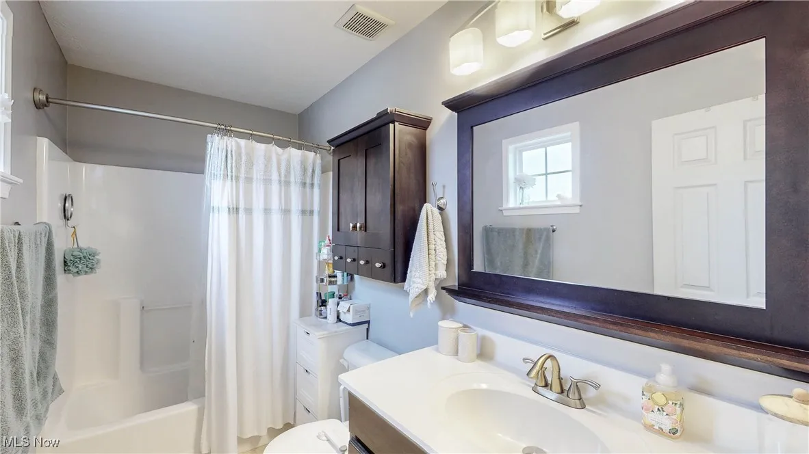 Full bathroom featuring vanity and shower / tub combo with curtain