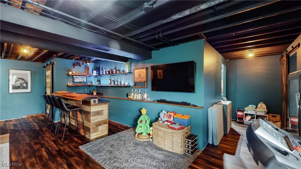 Indoor wet bar with dark wood-style floors