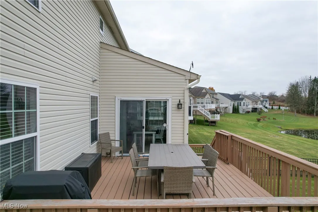 Deck featuring outdoor dining space, a yard, a residential view, and a water view