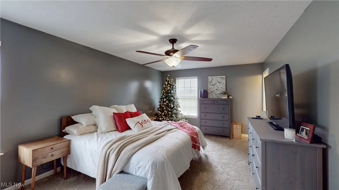 Bedroom with light carpet and ceiling fan