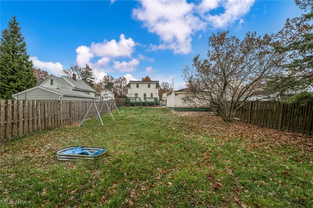 Fenced backyard featuring a playground