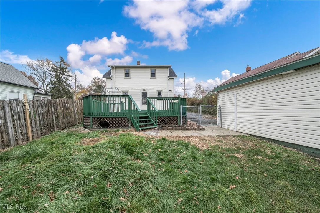 Back of property featuring a fenced backyard, a gate, a deck, and a patio area