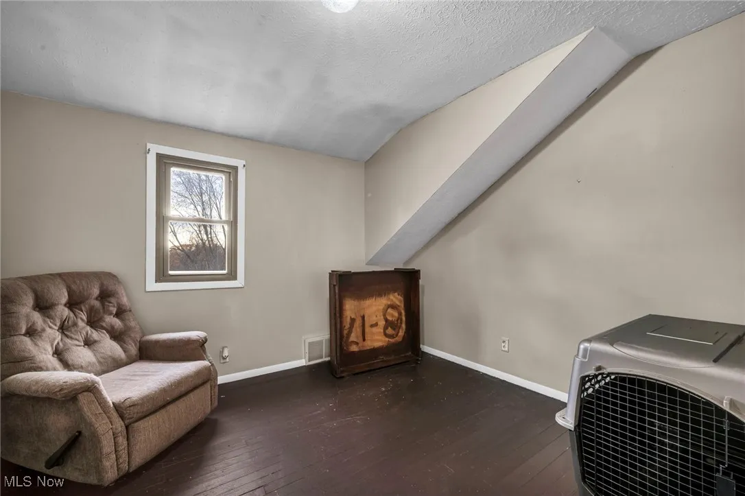 Living area with dark wood-style flooring and a textured ceiling
