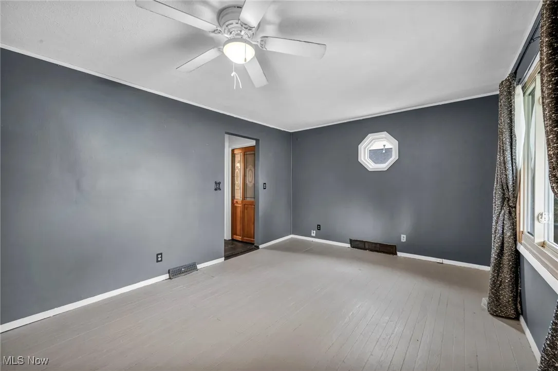 Spare room with light wood-style floors and a ceiling fan
