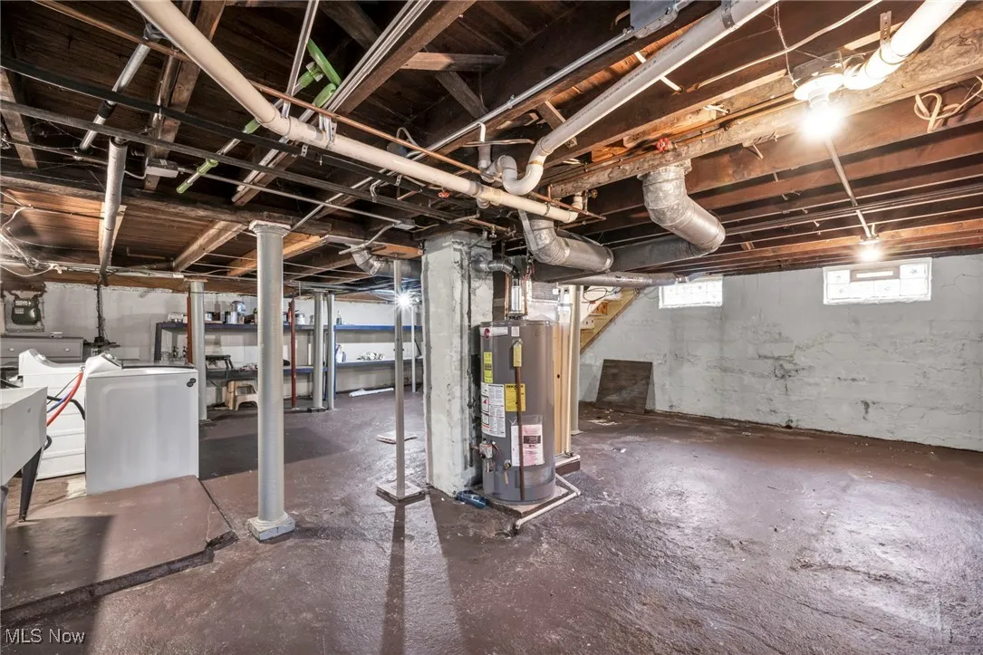 Below grade area featuring water heater and a sink