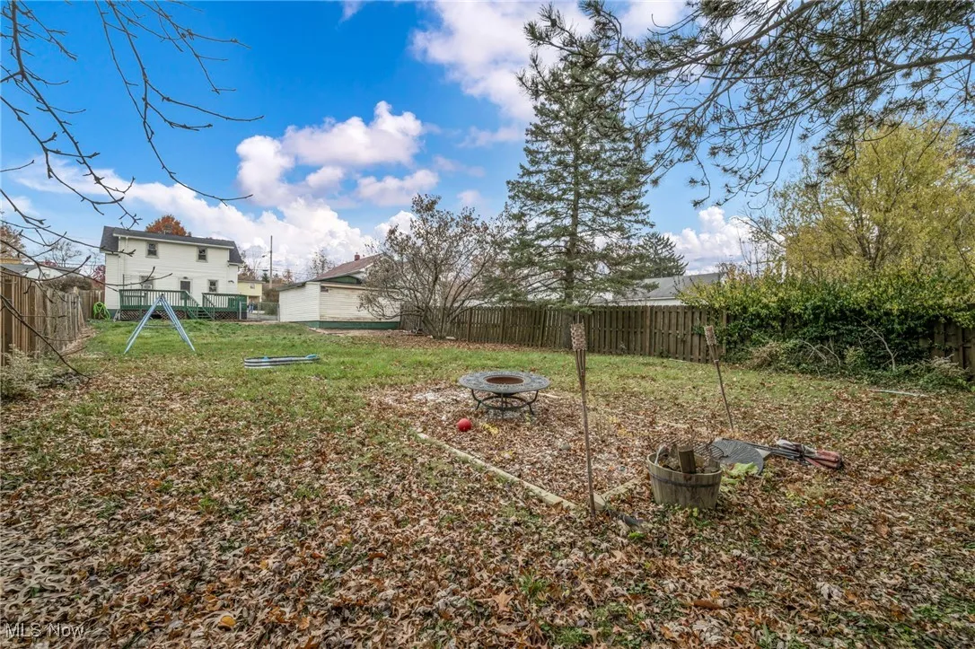 Fenced backyard with a fire pit