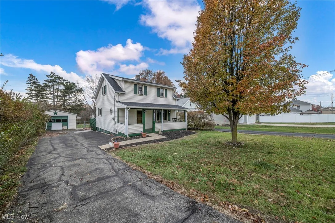 Traditional home with an outbuilding, a garage, a front yard, and a chimney