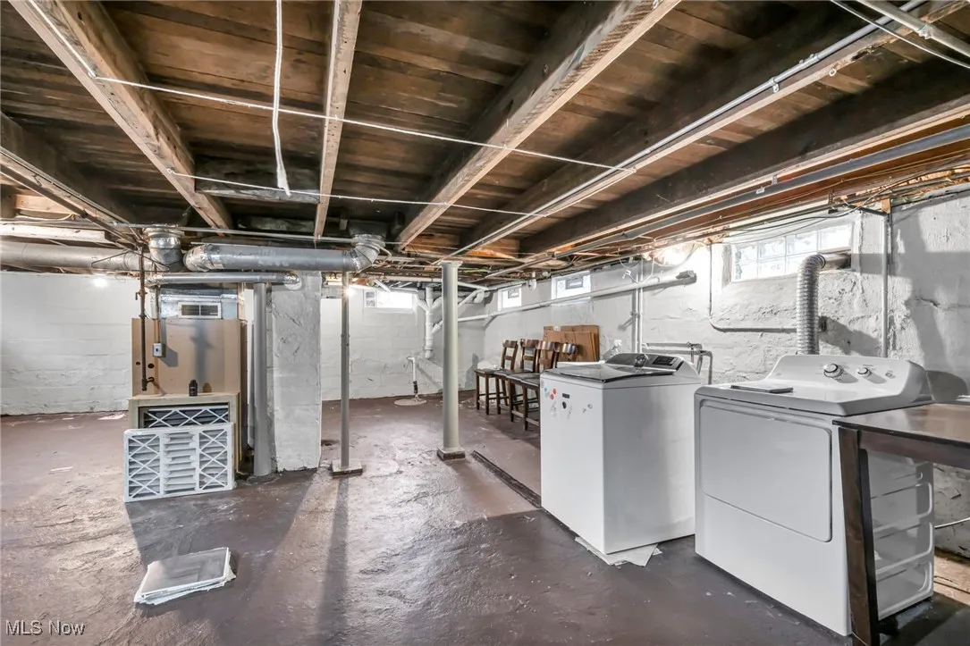 Below grade area featuring heating unit and independent washer and dryer