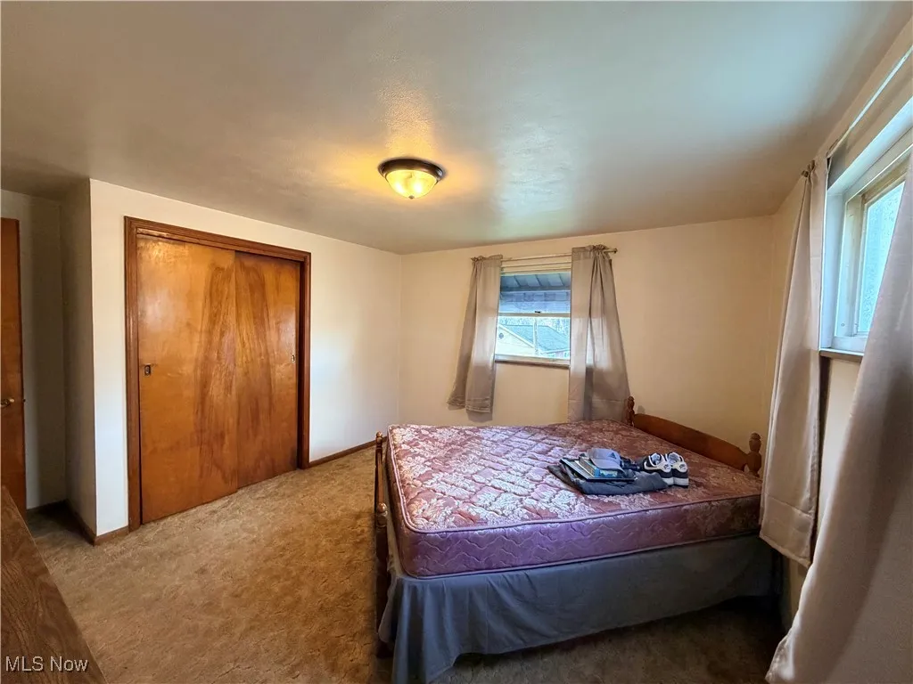 Carpeted bedroom featuring a closet